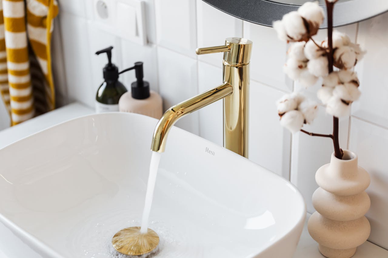 water running in sink with gold faucet