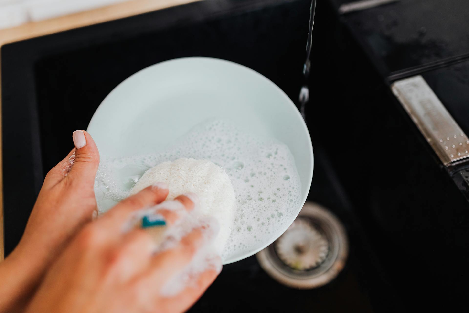 woman washing dishes in sink