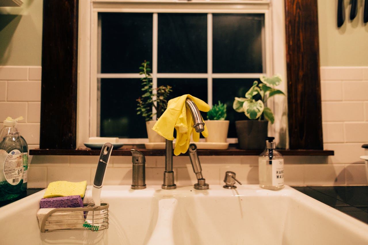kitchen sink at night with yellow gloves on sink