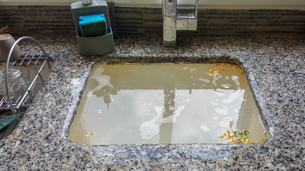 clogged kitchen sink with dirty water Coral Pelican Plumbing